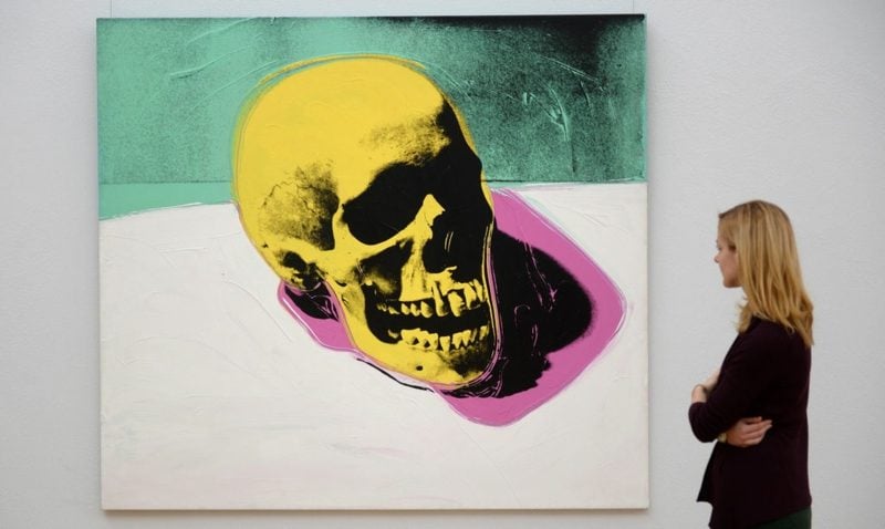epa04498086 A woman looks at the work 'Skull' (1976) by US artist Andy Warhol during a preview of the exhibition 'Andy Warhol - Death and Disaster' at the 'Kunstsammlung Chemnitz' museum in Chemnitz, Germany, 21 November 2014. The 61 pieces of Warhol's group of works entitled 'Death and Disaster' are on display at the museum until 22 February 2015. EPA/HENDRIK SCHMIDT