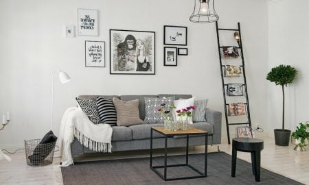 skandinavische Möbel Wohnzimmer origineller Teppich graues Polstersofa interessante Fotos und Bilder an der Wand