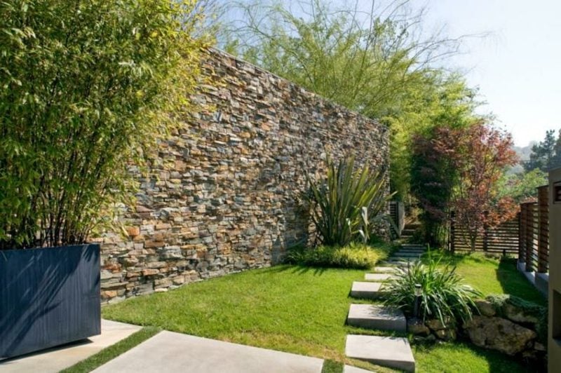 hohe Steinmauer als Sichtschutz im Garten