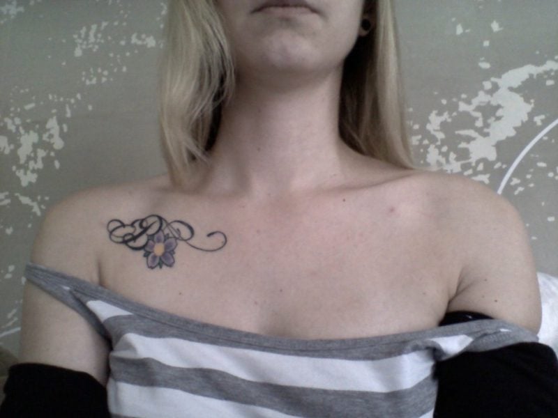 Dekolleté Tattoo klein Blume und Buchstabe einfach