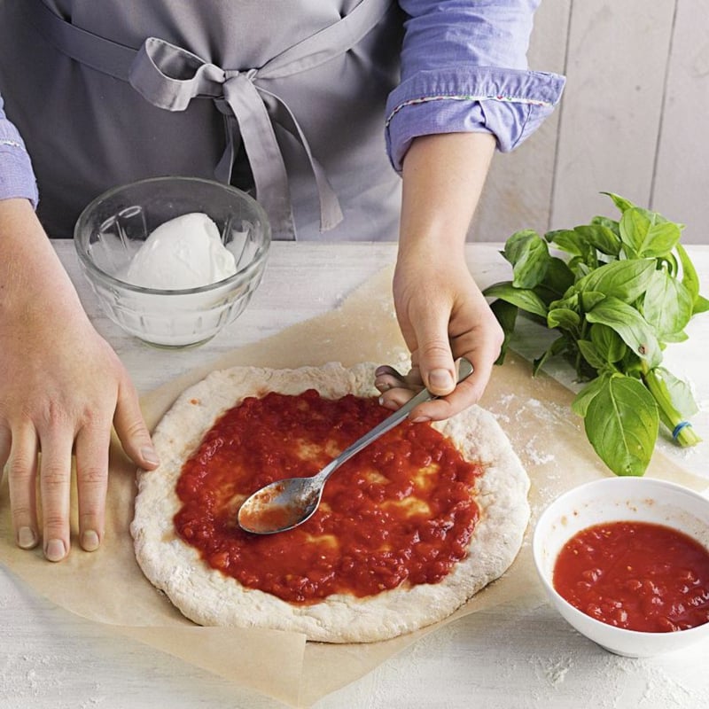 Pizzaboden mit Tomatensauce bestreichen