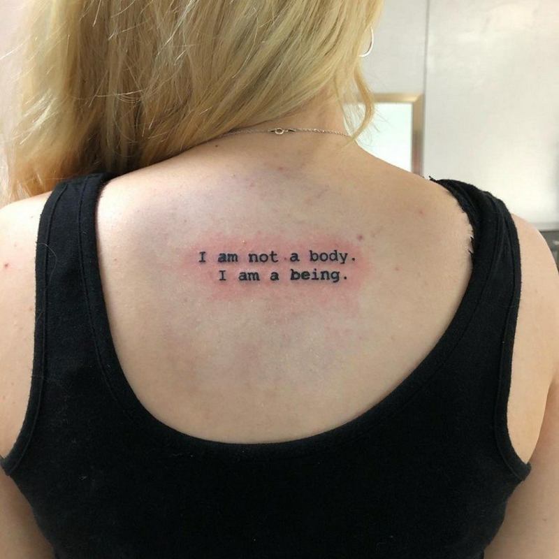Frau Tattoo am Rücken Spruch