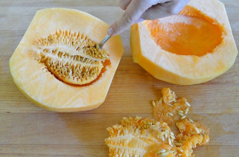Melone schneiden die Samen mit Löffel entfernen