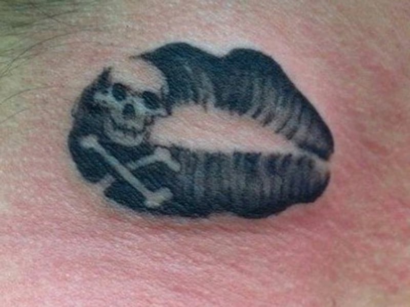 Kussmund Tattoo mit Schädel und Knochen